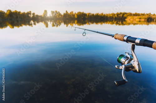 Plakaty wędkarstwo  reka-z-spinningiem-i-kolowrotkiem-na-letnim-jeziorze