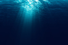 Perfectly Seamless Of Deep Blue Ocean Waves From Underwater Background With Micro Particles Flowing, Light Rays Shining Through