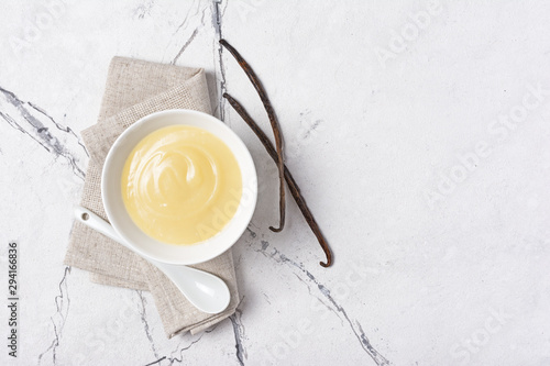 Cuadros en Lienzo Bowl of vanilla sauce with spoon