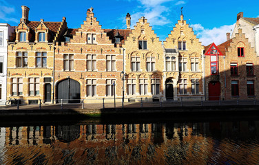 Scenic city view of Bruges canal with beautiful medieval colored houses and reflections.