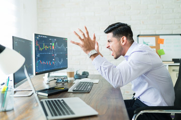 Wall Mural - male broker gesturing and screaming at computer