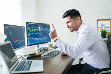 Wall Mural - handsome stock broker gesturing while trading online