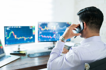 Wall Mural - Young Male Stock Broker Using Computer For Buying Shares