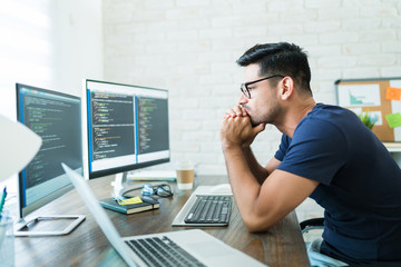 Wall Mural - attractive male coding on computer at desk