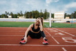 © Nomad_Soul - Tired female jogger sitting on the ground, stadium