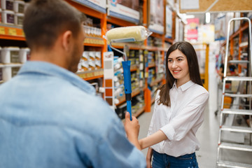 Young couple buying repair tools in hardware store