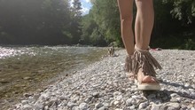 Slow Motion Woman Walking On Pristine River Bank, Small Yorkie And Maltese Dog Waiting In Background