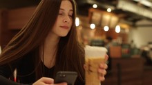 Girl Using Smartphone In Coffee Shop, Medium Close Up Shot