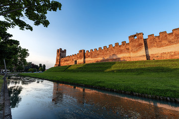 Sticker - Castelfranco Veneto town, the ancient medieval walls at sunset (XII-XIII century) with the moat full of water and the embankment. Treviso province, Italy, Europe