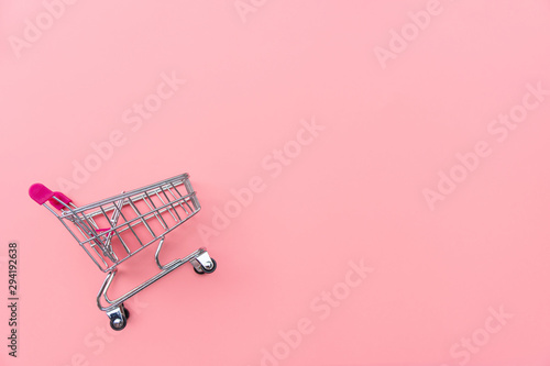 Fotografía Empty shopping cart on pink background
