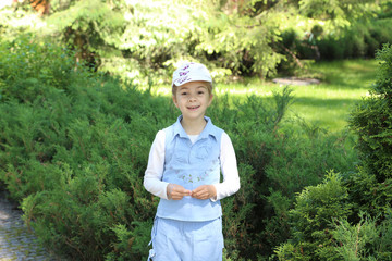 Little cute girl in a green summer park