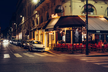 Wall Mural - cozy street with tables of cafe in paris at night, france