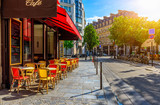 Fototapeta Uliczki - Cozy street with tables of cafe in Paris, France