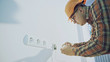 © procinemastock - Builder with screwdriver fixing socket indoors