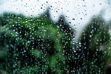 raindrops on the glass outside the window cloudy sky and greenery