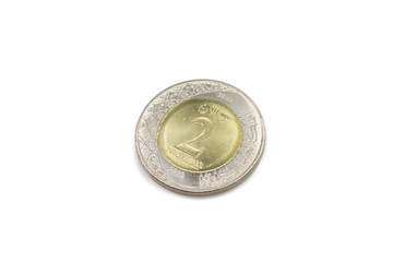 A close up image of a bimettalic, two Saudi Riyal gold and silver coin, in macro, on a clean, white background