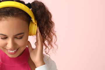 Poster - Beautiful African-American woman listening to music on color background