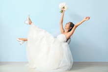 Happy Young Asian Bride Near Color Wall