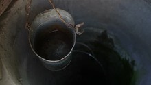 A Leaky Leaking Bucket Hangs In A Well. A Water Well.