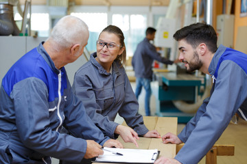 factory workers with clipboard working together