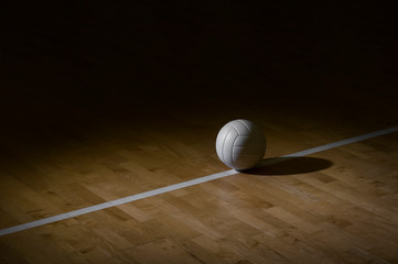 Volleyball court wooden floor with ball on black with copy-space