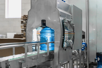 Wall Mural - Water bottling conveyor line with plastic bottles or gallons on water factory production