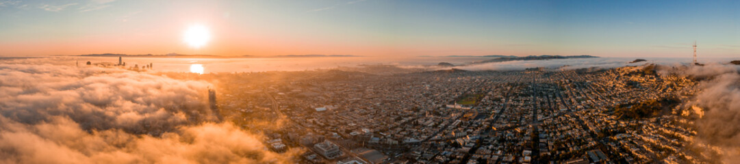 Fototapete - Beautiful cloudy morning in San Francisco, USA. Sunset over the clouds with skyscrapers rising through the clouds.