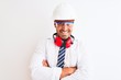 © Krakenimages.com - Young chemist man wearing security helmet and headphones over isolated background happy face smiling with crossed arms looking at the camera. Positive person.
