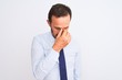 © Krakenimages.com - Middle age businessman wearing elegant tie standing over isolated white background tired rubbing nose and eyes feeling fatigue and headache. Stress and frustration concept.