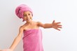 © Krakenimages.com - Beautiful child girl wearing shower towel after bath standing over isolated white background looking at the camera smiling with open arms for hug. Cheerful expression embracing happiness.
