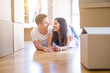 © Krakenimages.com - Young beautiful couple lying down at new home around cardboard boxes