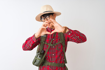 Sticker - Chinese hiker man wearing backpack canteen glasses hat over isolated white background smiling in love showing heart symbol and shape with hands. Romantic concept.