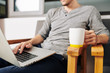 © DragonImages - Man sitting in chair with big mug of coffee and working on new website for his company