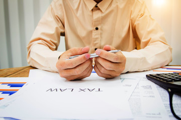 Hand man doing calculate and thinking on desk about tax at home office.