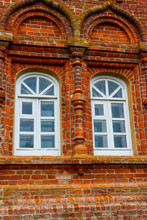 Two Rounded Windows On Old Red Brick Wall