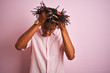Afro american man with dreadlocks wearing elegant shirt standing over isolated pink background suffering from headache desperate and stressed because pain and migraine. Hands on head.