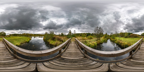 Wall Mural - full seamless spherical hdri panorama 360 degrees  angle view on wooden bridge over the river canal with gray pale clouds in sky in equirectangular projection with zenith and nadir, VR AR content.