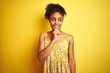 © Krakenimages.com - African american woman wearing casual floral dress standing over isolated yellow background with hand on chin thinking about question, pensive expression. Smiling and thoughtful face. Doubt concept.