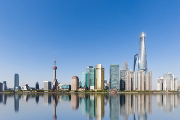 Wall Mural - shanghai skyline and reflection against a sunny sky