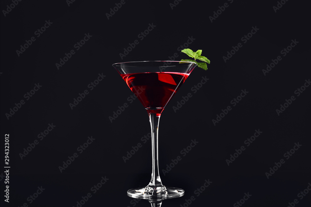 Glass of tasty cocktail on dark background