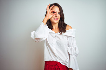 Wall Mural - Young beautiful woman wearing t-shirt standing over white isolated background doing ok gesture with hand smiling, eye looking through fingers with happy face.