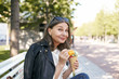 © shurkin_son - Portrait of fashionable mature European woman eating tasty ice cream cone, sitting outdoors on bench in park, having pleased joyful facial expression, her look expressing delight, saying Yummy