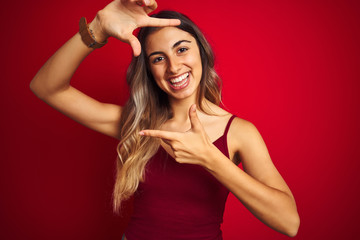 Poster - Young beautiful woman wearing a t-shirt over red isolated background smiling making frame with hands and fingers with happy face. Creativity and photography concept.