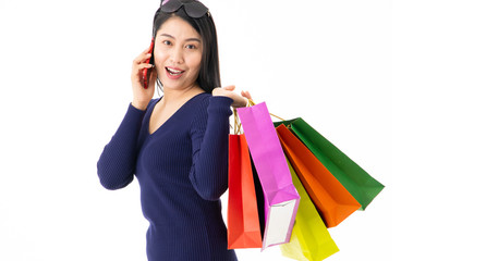 Girl with a shopping bag walking on mobile phone talking on White background Happy with shopping