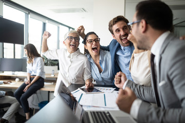 Happy business people celebrating success at company