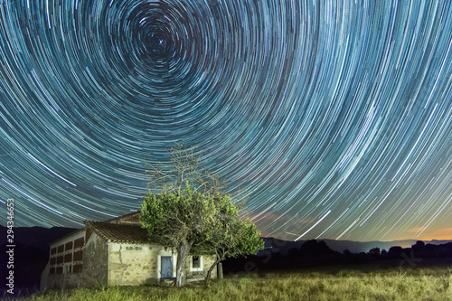 Cuadros en Lienzo Star trails with shooting stars on a country house