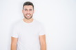 © Krakenimages.com - Young handsome man wearing casual white t-shirt over white isolated background with a happy and cool smile on face. Lucky person.
