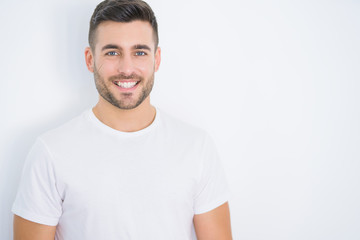 Young handsome man smiling happy wearing casual white t-shirt over white isolated background