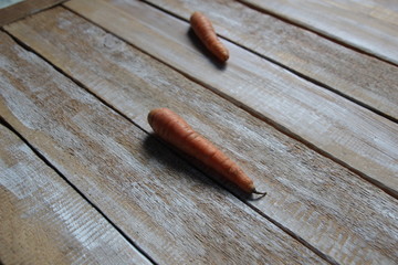 two unpeeled carrots on wooden background