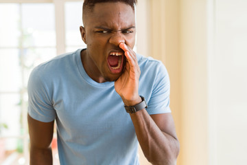 Wall Mural - African american man shouting with rage, yelling excited with hand on mouth